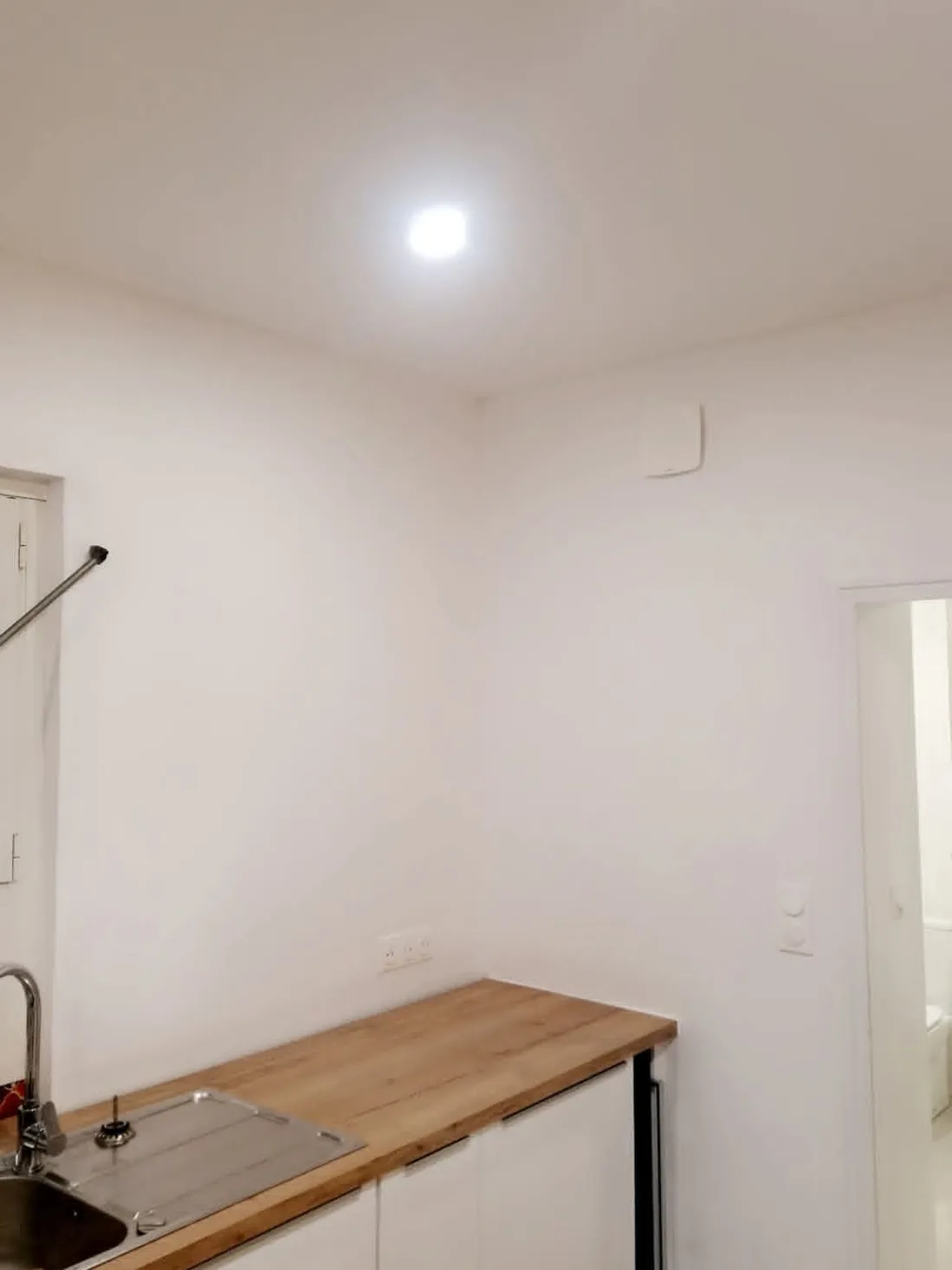 Cuisine après travaux : Enduits repris, murs et plafond remis en peinture blanche.