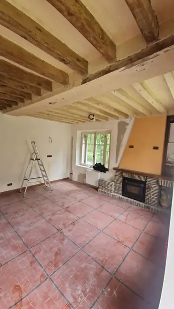 Pièce de vie avec cheminée en briques, plafond à la française remis en peinture